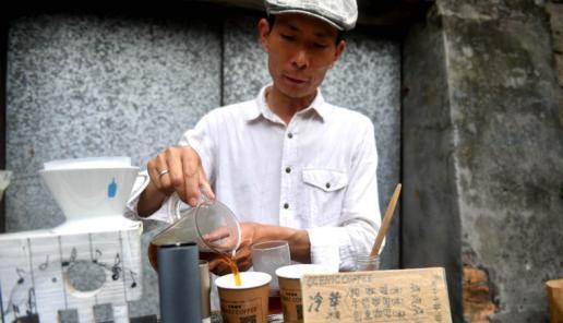 刘运平正在专心致志地磨着咖啡豆。吕明 摄 吕明 摄